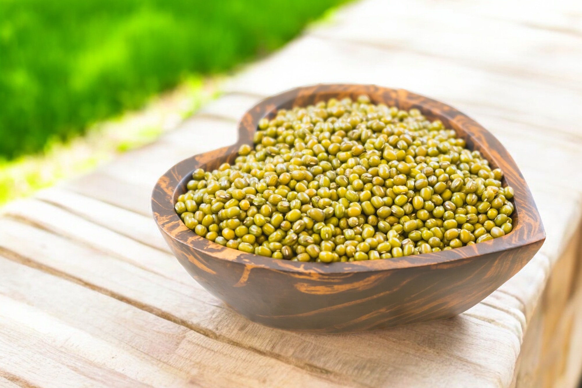 A close-up of whole green gram beans (mung beans), showcasing their small, oval shape and vibrant green color, ideal for nutritious soups, curries, and salads.